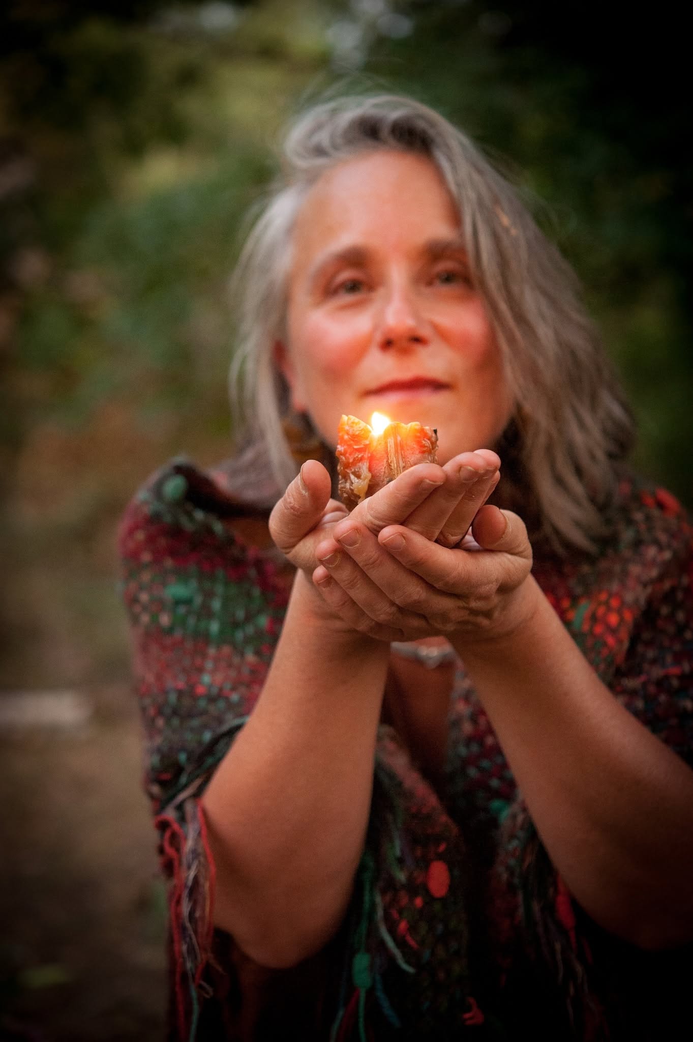 Asherah Boyer holding a lit candle outdoors